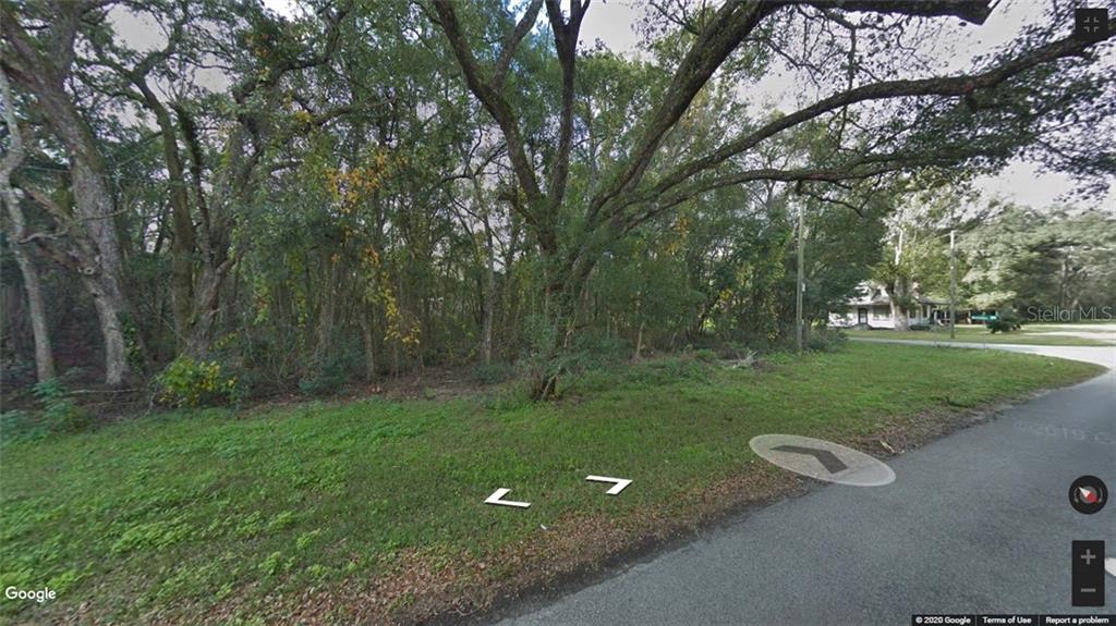 A wooded, undeveloped residential lot sits at the corner of a paved street — 0 BROAD STREET, BROOKSVILLE, FL