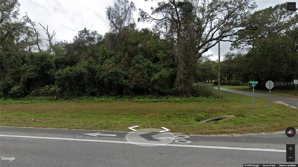 A vacant, wooded corner lot sits at the intersection of two paved roads — 0 BROAD STREET, BROOKSVILLE, FL