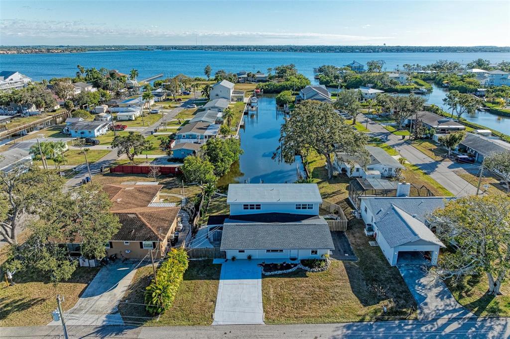 An aerial view shows a residential neighborhood with a canal leading to a large body — 3311 WATER STREET, ELLENTON, FL