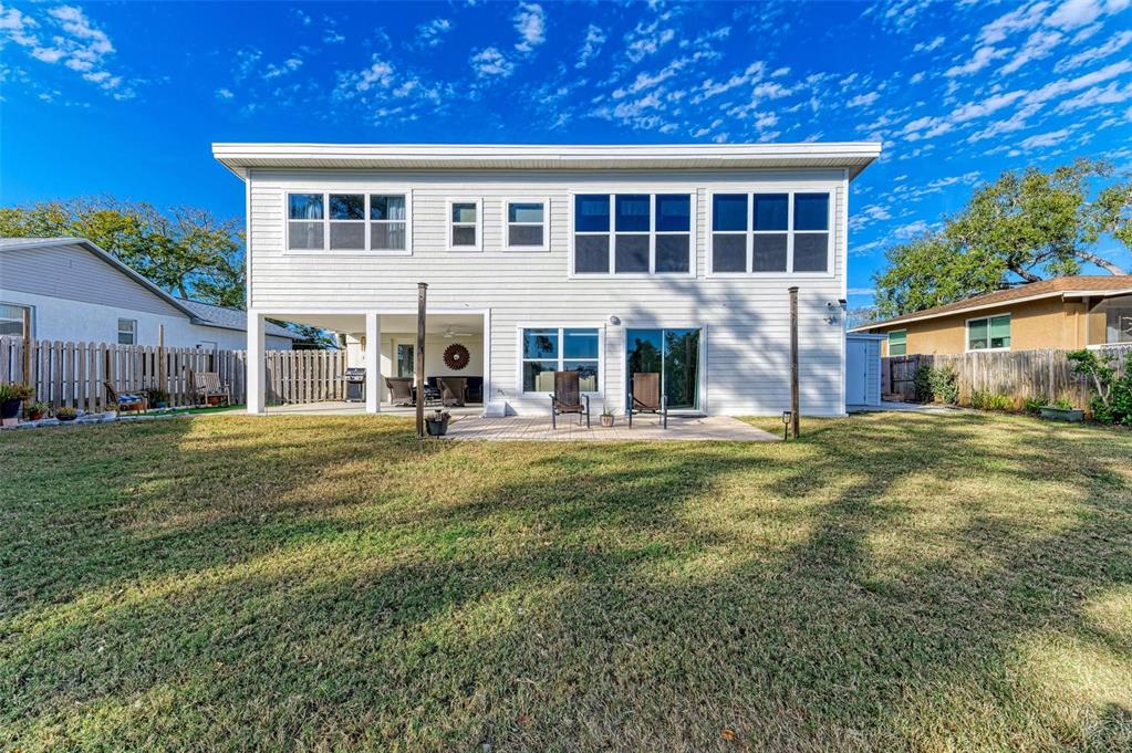 The rear exterior of a two-story house features white siding, a patio, and a lawn — 3311 WATER STREET, ELLENTON, FL