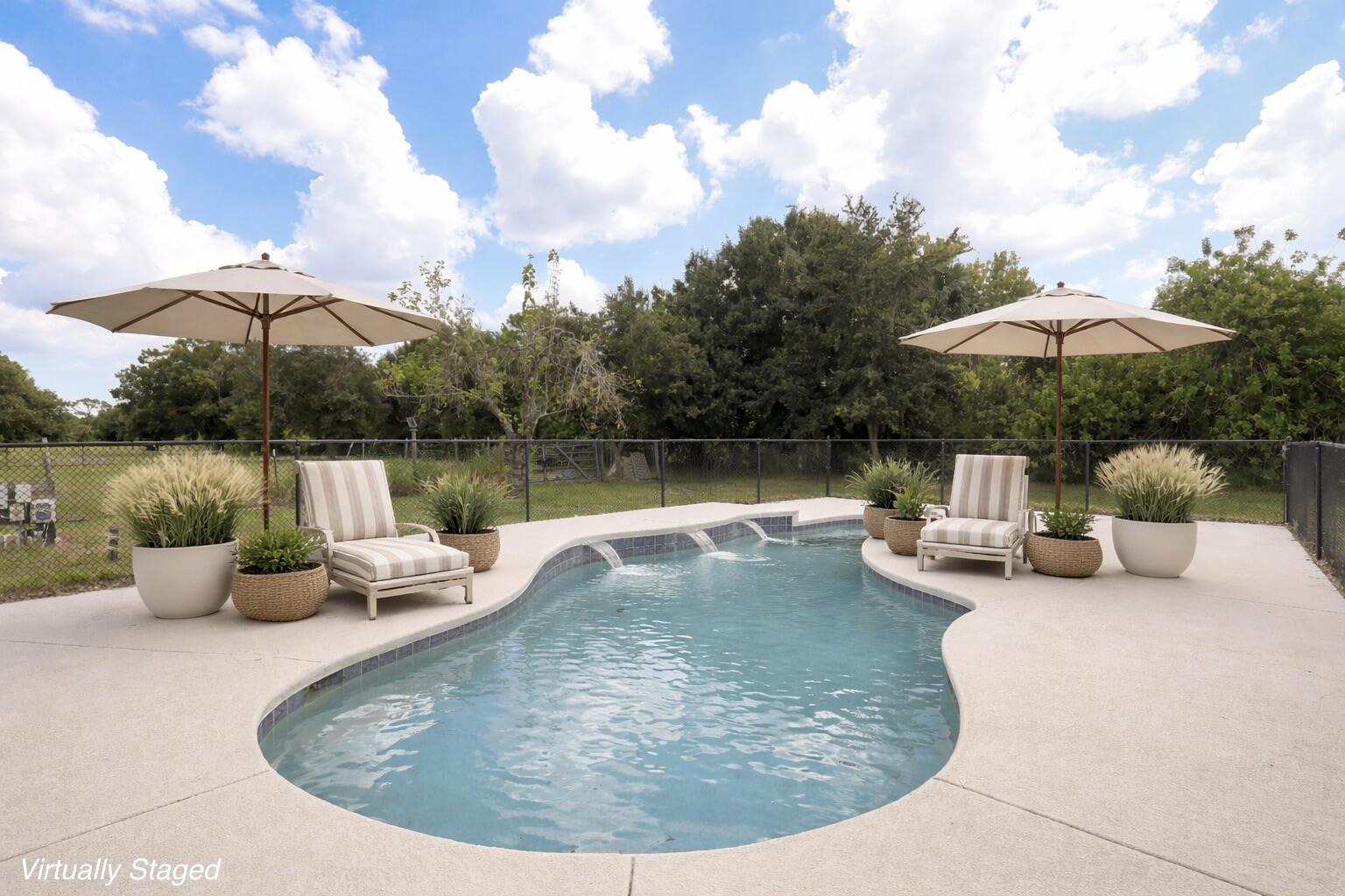 A swimming pool with two lounge chairs and umbrellas on a concrete patio — 6080 65th Street, Vero Beach FL 32967, VERO BEACH, FL
