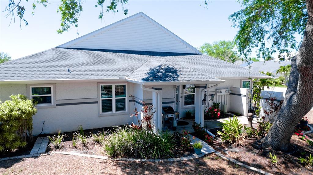 A single-story house with a gray shingled roof, light-colored stucco walls, and a small porch — 11009 JASMINE CIRCLE, BRADENTON, FL