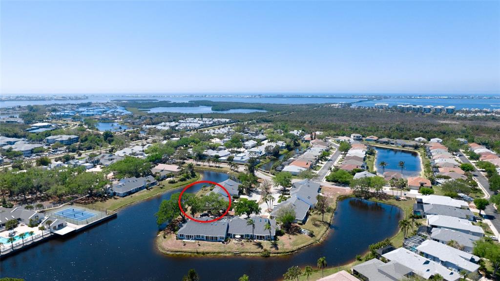 An aerial view shows a residential neighborhood with houses situated along a winding canal — 11009 JASMINE CIRCLE, BRADENTON, FL