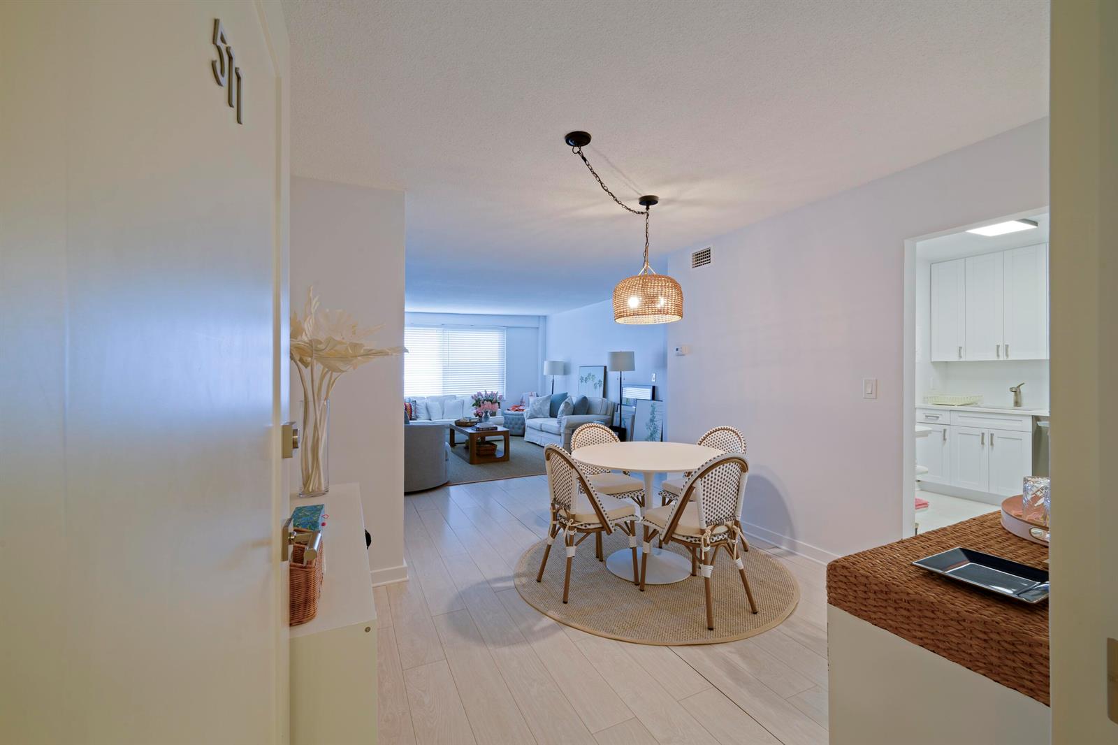 A dining area with a round table and chairs sits between a kitchen and living room — 170 N Ocean Boulevard # 511, Palm Beach FL 33480, PALM BEACH, FL