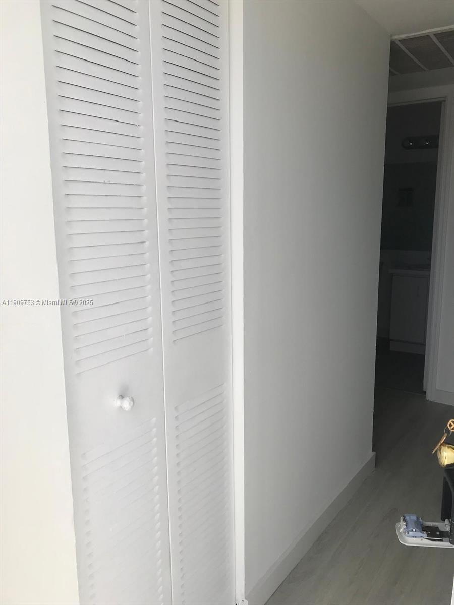 A white louvered closet door stands next to a doorway leading into another room — 438 NE 210th Cir Ter # 4B, Miami FL 33179, MIAMI, FL