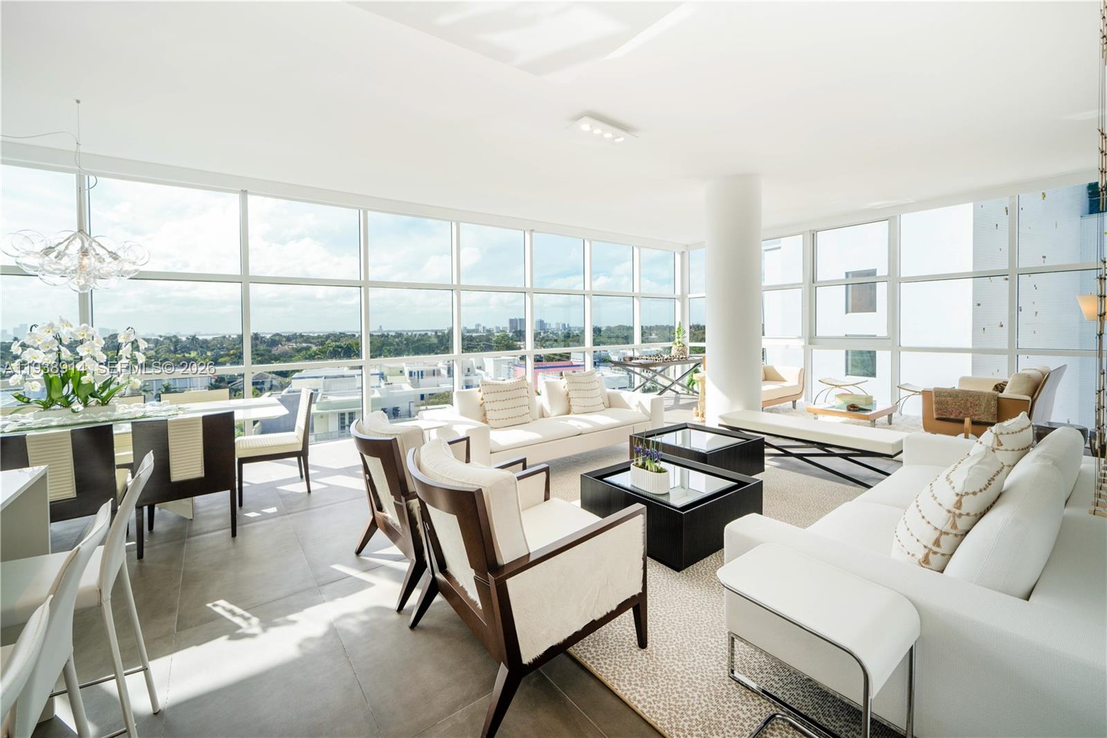 A bright, modern living and dining area features floor-to-ceiling windows with expansive city views — 6103 Aqua Ave # 701, Miami Beach FL 33141, MIAMI BEACH, FL