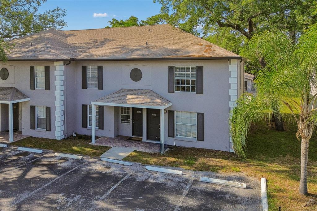An exterior view of a two-story apartment building with a parking lot in front — 5156 SUNRIDGE PALMS DRIVE, TAMPA, FL