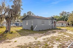 A gray, single-story house with a gabled roof stands on a sandy, grassy lot — 131 W CRYSTAL AVENUE, LAKE WALES, FL