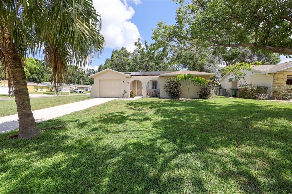 A single-story house with a beige exterior, a garage, and a large front lawn — 160 MEADOWLARK DRIVE, SAFETY HARBOR, FL