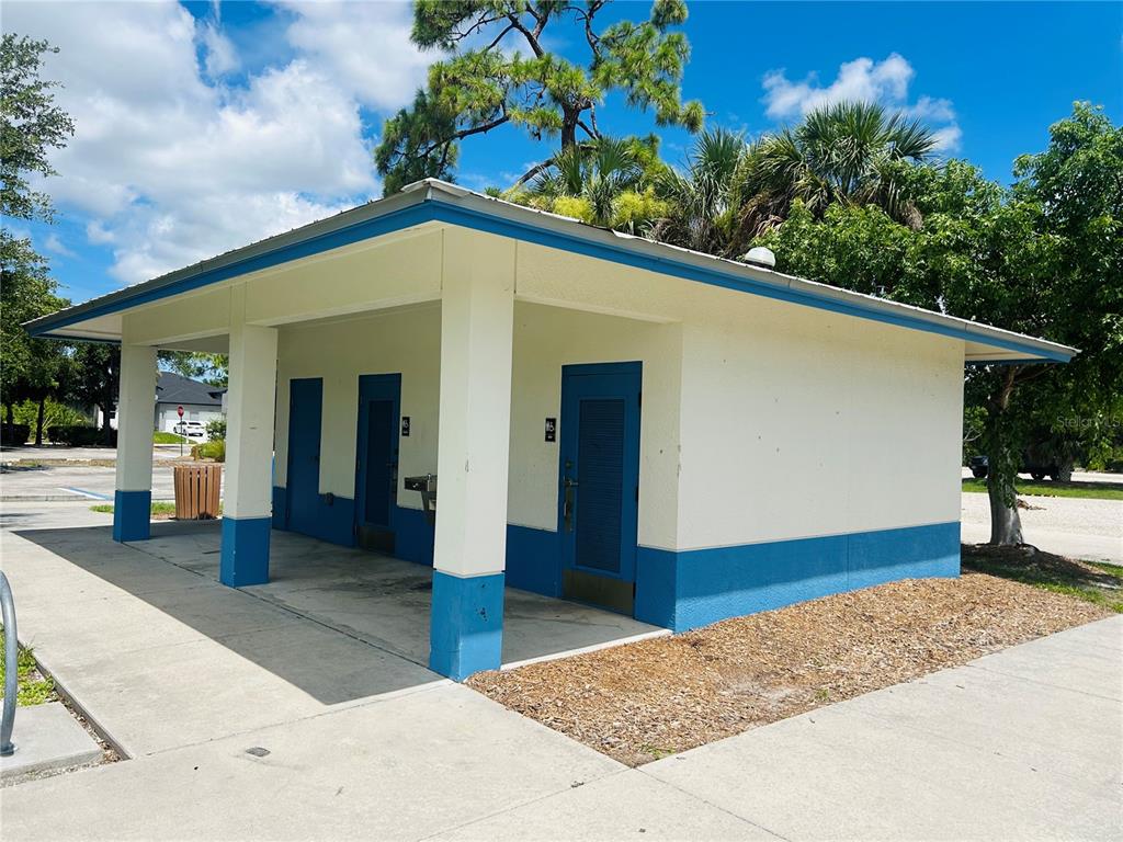 A small, single-story public restroom building with a blue and white exterior — 15714 STUART CIRCLE, PORT CHARLOTTE, FL