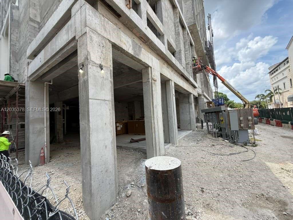 A construction site shows a concrete building frame with an orange boom lift nearby — 4011 SALZEDO ST, FL 33146, FL
