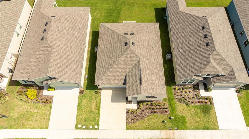 An aerial view shows three suburban houses with shingled roofs and concrete driveways — 4278 GREEN GABLES PLACE, KISSIMMEE, FL