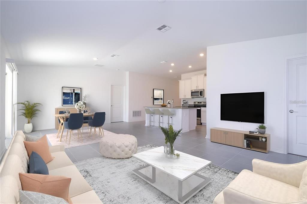 This open-concept living room features tile flooring, a kitchen island, and a dining area — 4278 GREEN GABLES PLACE, KISSIMMEE, FL