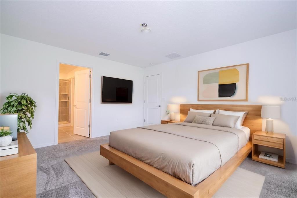 A bedroom features a platform bed, light wood furniture, gray carpeting, and an attached bathroom — 4278 GREEN GABLES PLACE, KISSIMMEE, FL
