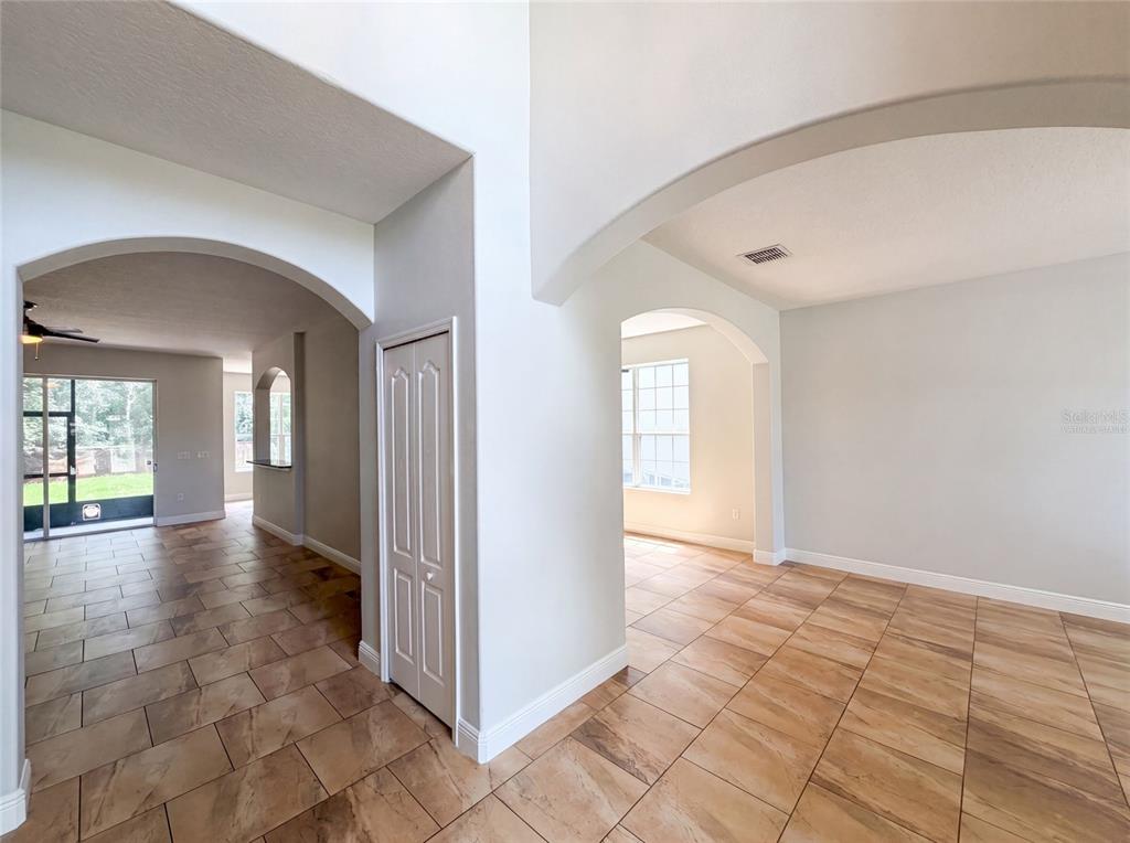 An interior view shows tiled floors, arched doorways, and a white closet door — 12706 GROVEHURST AVENUE, WINTER GARDEN, FL