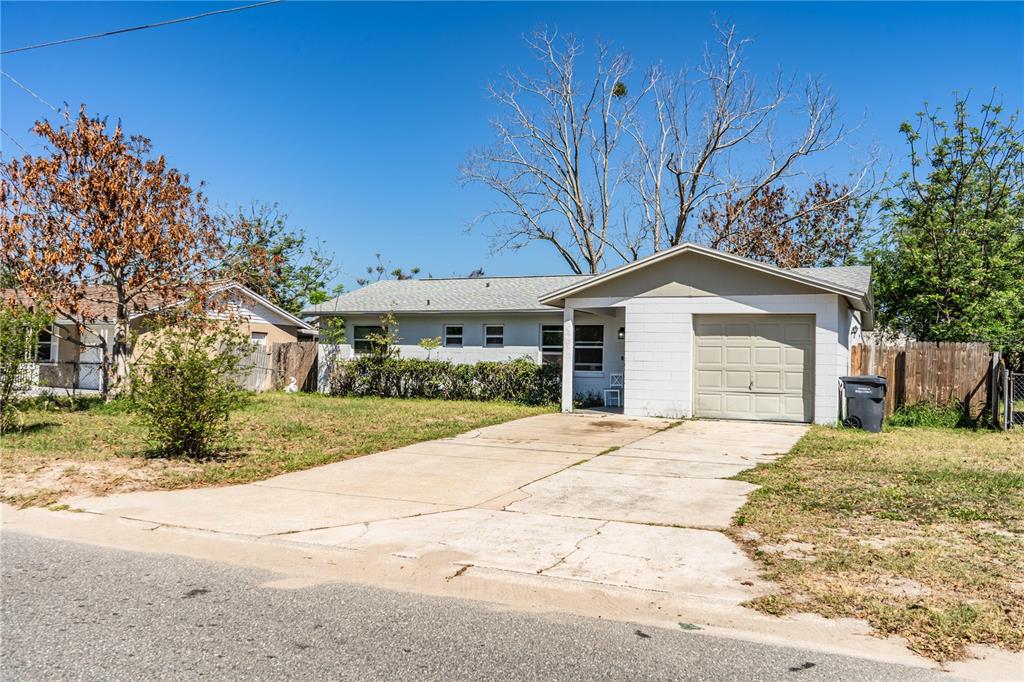 A single-story house with a concrete driveway, a one-car garage, and a front yard — 1015 CAREFREE COVE DRIVE, WINTER HAVEN, FL