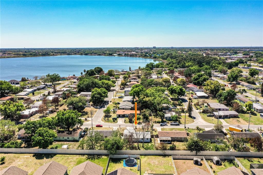 An aerial view shows a residential neighborhood with a lake in the background — 1015 CAREFREE COVE DRIVE, WINTER HAVEN, FL