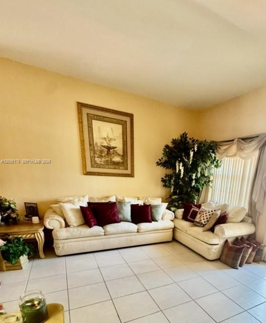 A living room features a beige sofa and loveseat with tiled floors and wall art — 18201 SW 144th Ct, Miami FL 33177, MIAMI, FL