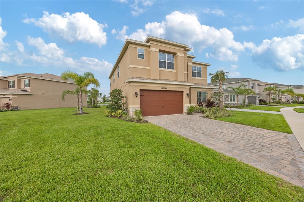 A two-story tan stucco house with a brown garage and a paved driveway — 3488 GREAT BANYAN WAY, WESLEY CHAPEL, FL