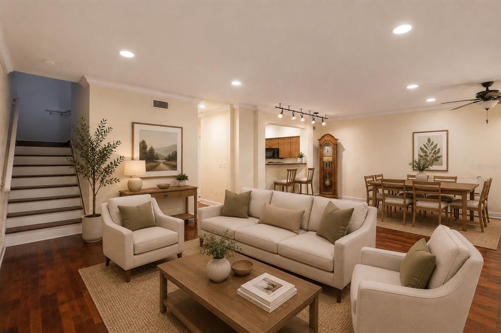 A living room features a sofa, two armchairs, a dining area, and a staircase — 202 E SOUTH STREET UNIT 1044, ORLANDO, FL