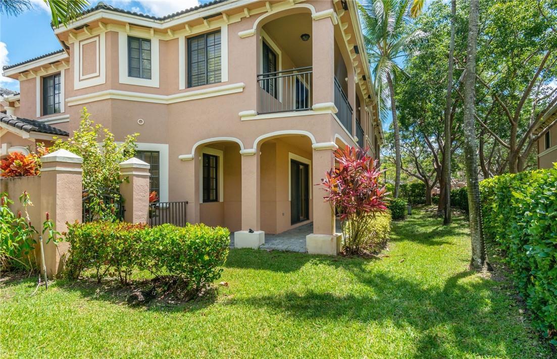 A two-story tan stucco townhouse with a covered patio, balcony, and landscaped yard — 2692 Center Ct Drive # 32, Weston FL 33332, WESTON, FL