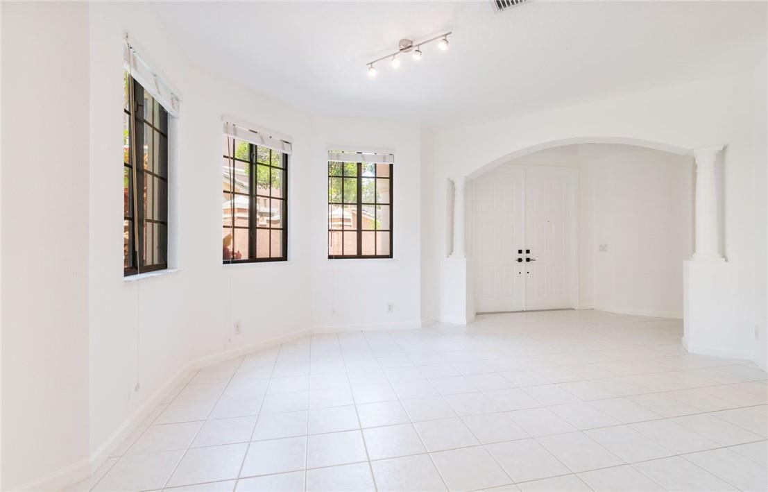 An empty room with white walls, tiled floors, three windows, and an arched entryway — 2692 Center Ct Drive # 32, Weston FL 33332, WESTON, FL
