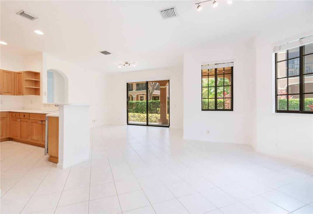 An open-concept living area features white tile flooring, light wood cabinets, and large windows — 2692 Center Ct Drive # 32, Weston FL 33332, WESTON, FL
