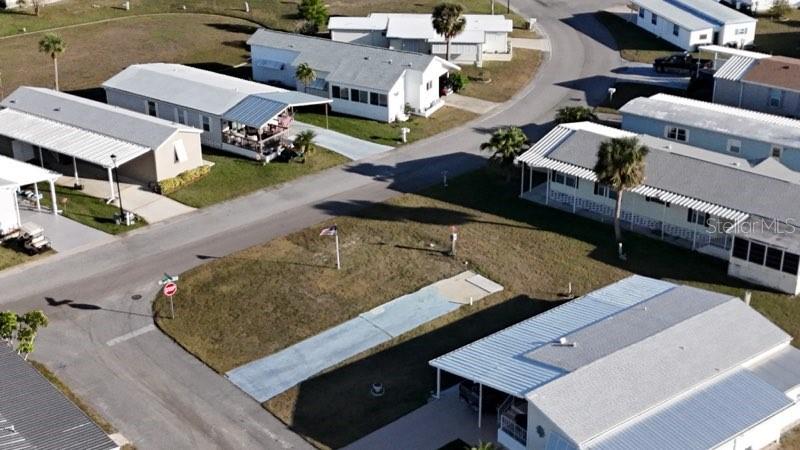 An aerial view shows several mobile homes with carports and a vacant lot — 6704 NEIGHBORLY COURT, NORTH PORT, FL