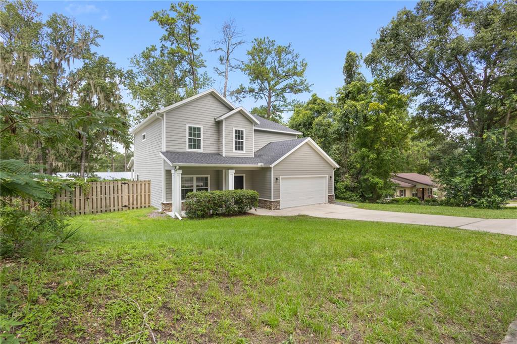 A two-story house with gray siding, a two-car garage, and a front lawn — 16 NW 29 STREET, GAINESVILLE, FL