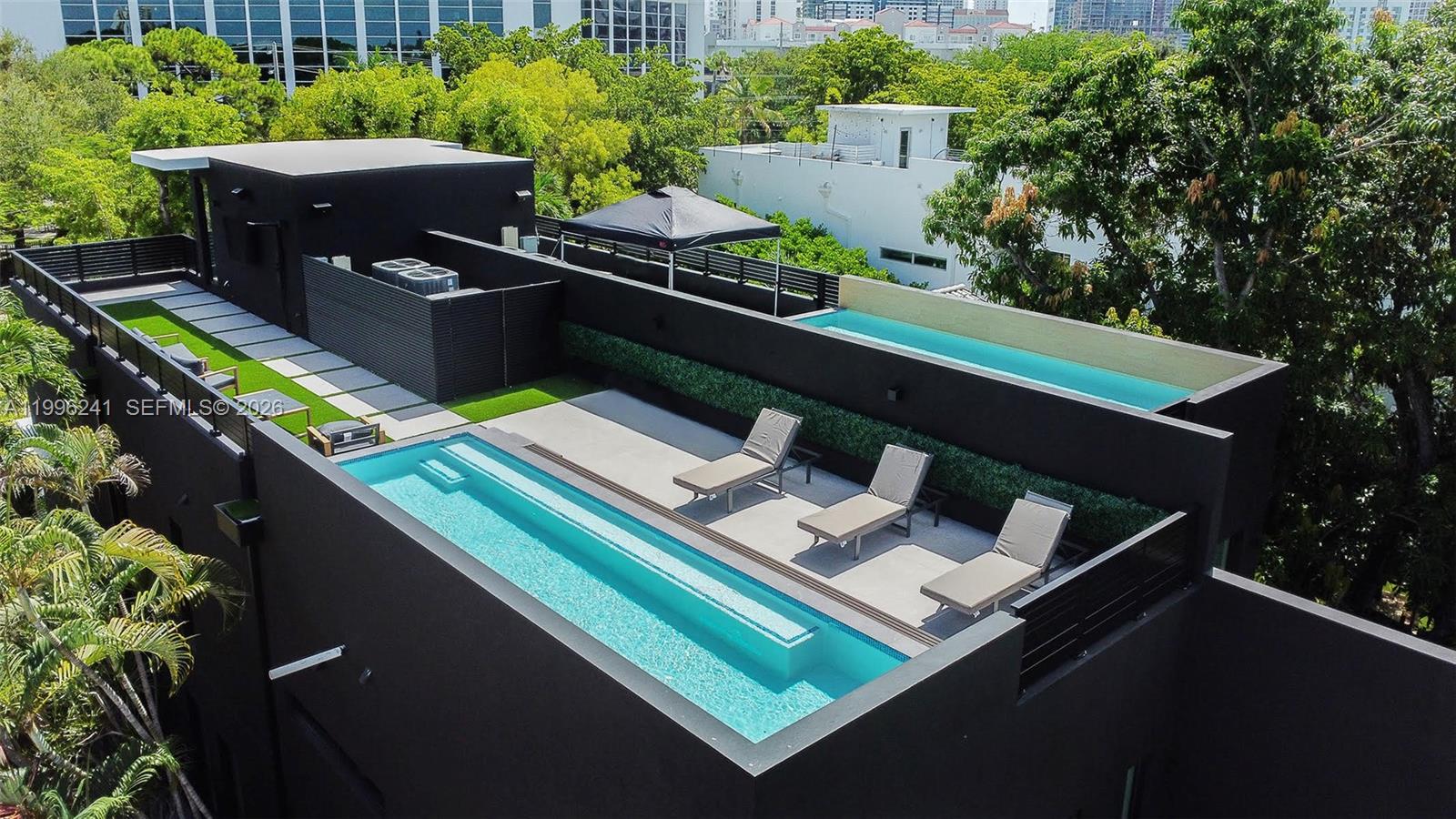 An aerial view of a rooftop terrace featuring two swimming pools and lounge chairs — 420 SW 15th Rd # 420, Miami FL 33129, MIAMI, FL
