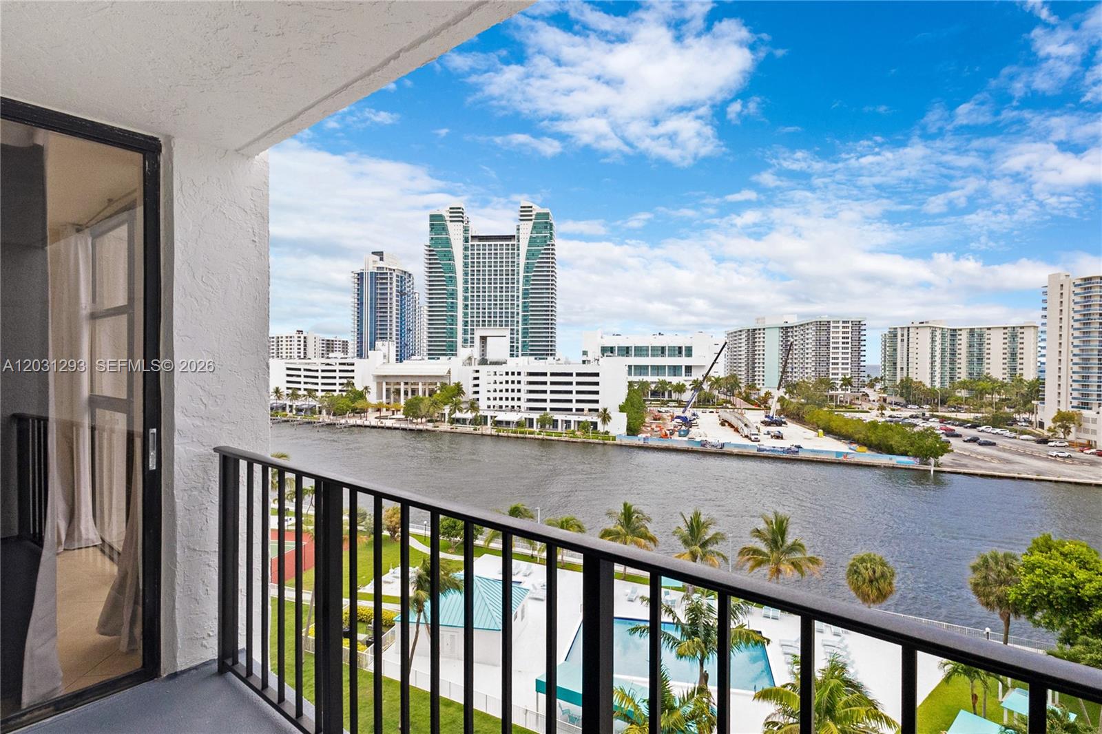 A balcony overlooks a river, swimming pool, and a city skyline with high-rise buildings — 200 Leslie Dr # 902, Hallandale Beach FL 33009, HALLANDALE BEACH, FL