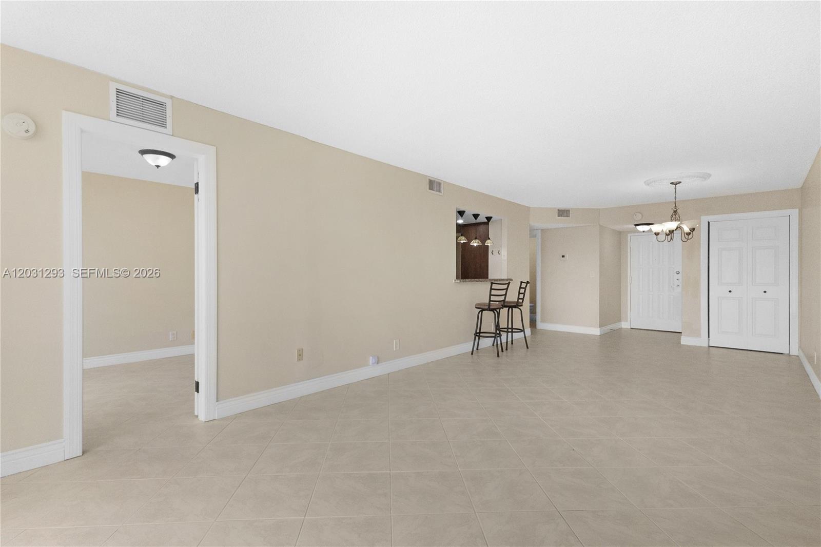This living area features beige tile flooring, a breakfast bar, and a white front door — 200 Leslie Dr # 902, Hallandale Beach FL 33009, HALLANDALE BEACH, FL
