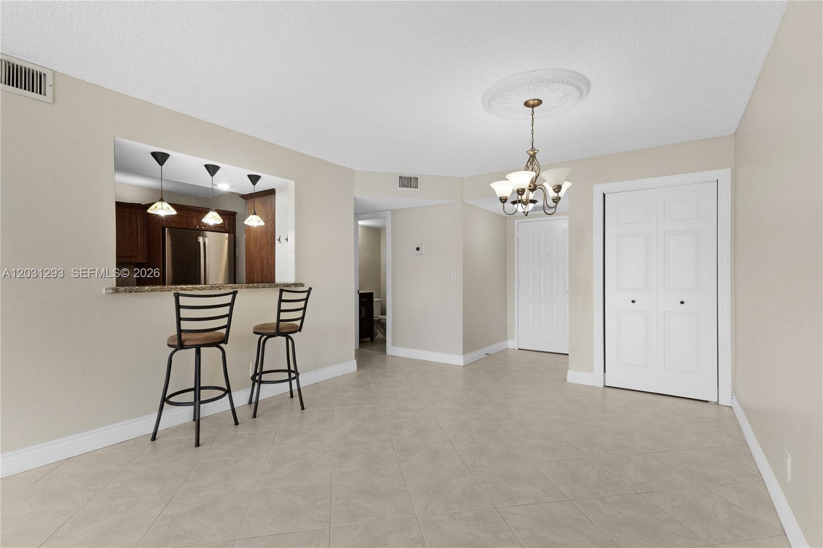 A dining area features tile flooring, a breakfast bar with stools, and a chandelier — 200 Leslie Dr # 902, Hallandale Beach FL 33009, HALLANDALE BEACH, FL