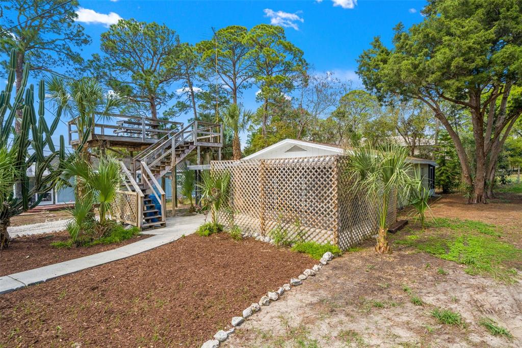 An exterior view of a house featuring a wooden observation deck and lattice privacy fencing — 4489 FISHMAN AVENUE, WEEKI WACHEE, FL