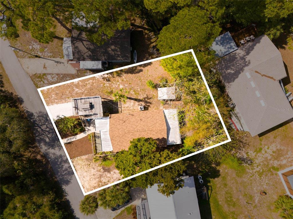 An aerial view shows a house with a shingled roof and deck on a lot — 4489 FISHMAN AVENUE, WEEKI WACHEE, FL