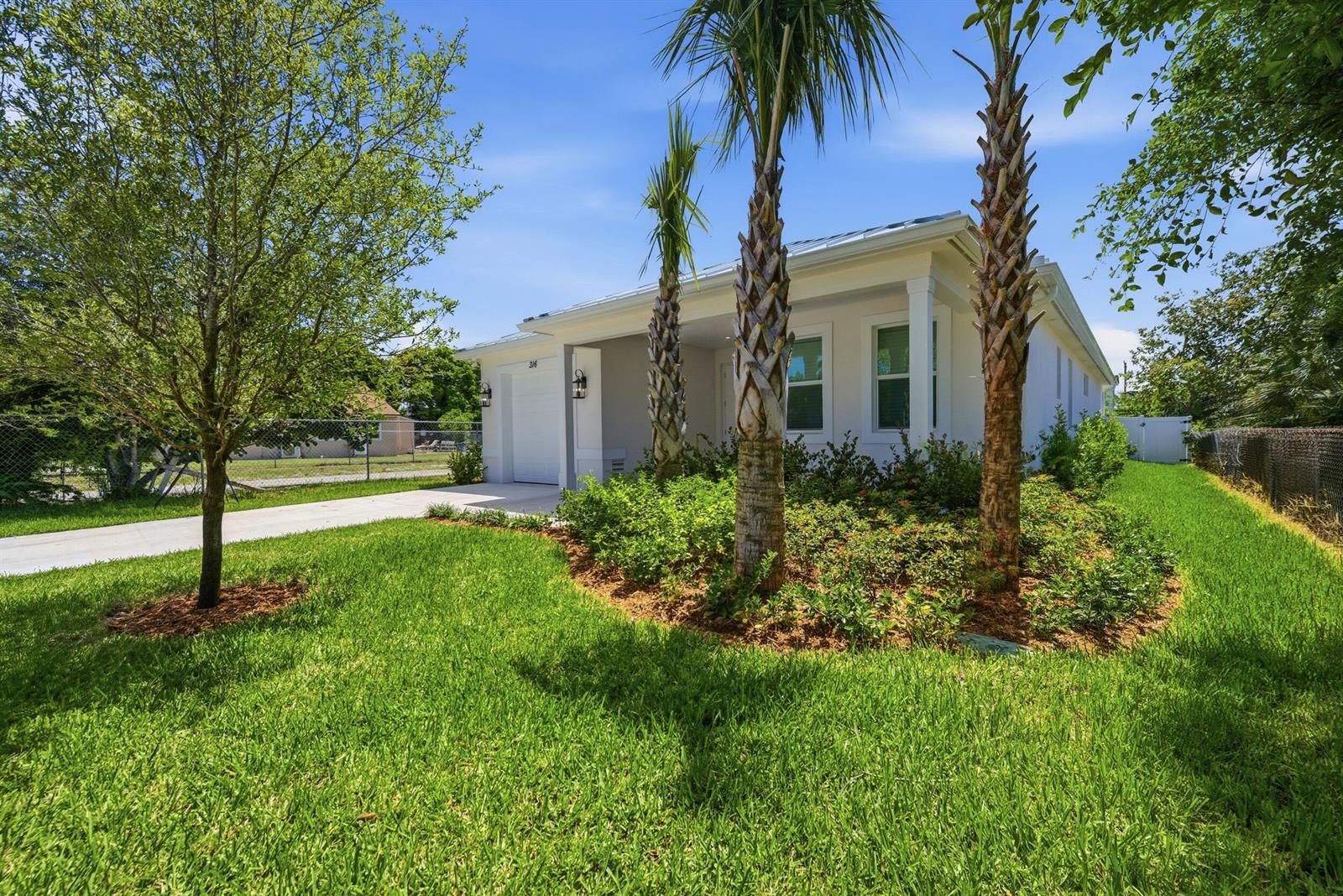 A white single-story house features a concrete driveway, palm trees, and a landscaped front yard — 316 SW 4th Avenue, Delray Beach FL 33444, DELRAY BEACH, FL