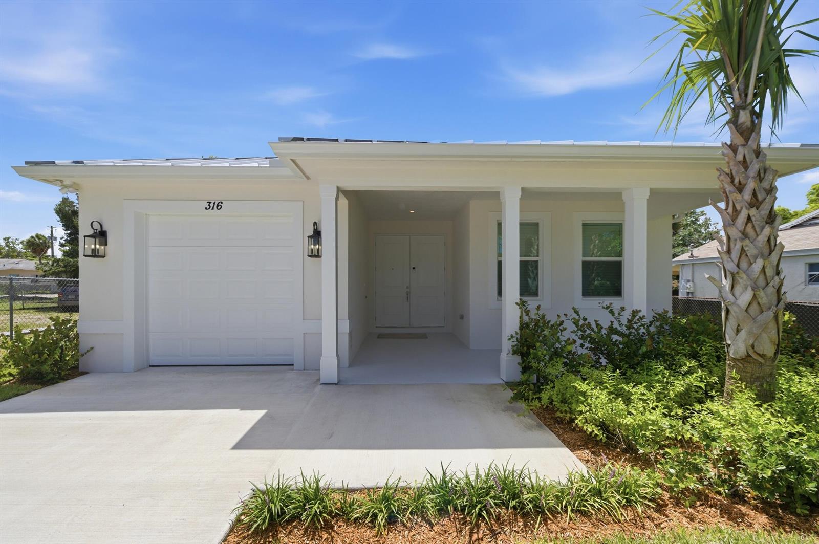A single-story house exterior features a white garage, a covered entryway, and a palm tree — 316 SW 4th Avenue, Delray Beach FL 33444, DELRAY BEACH, FL