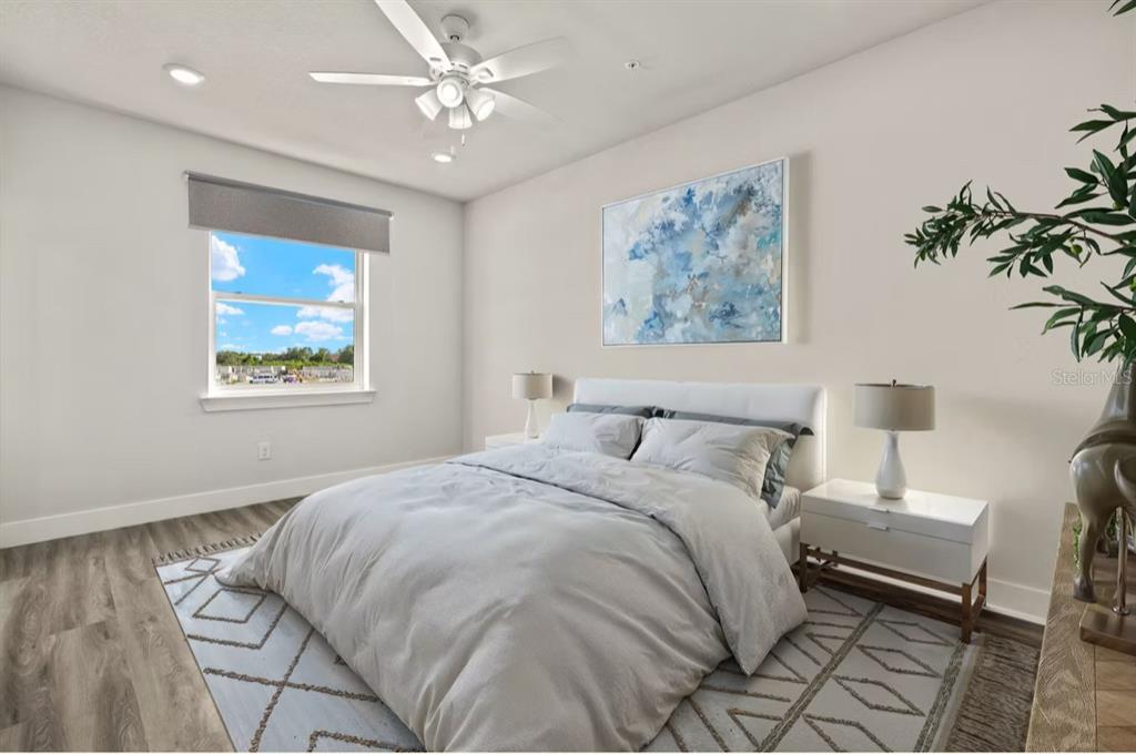 A bedroom features a bed with grey bedding, a ceiling fan, and a window — 14987 SUNSET EVE LOOP, FORT MYERS, FL