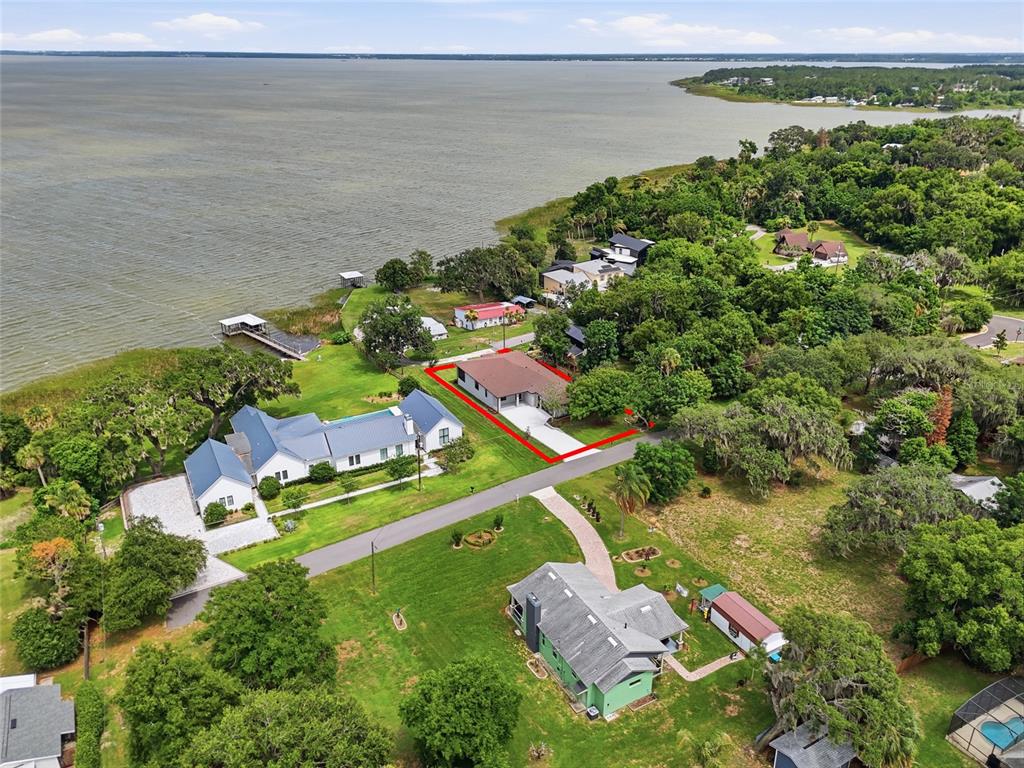 An aerial view shows a house with a red outline situated near a large lake — 17540 THIRD STREET, MONTVERDE, FL
