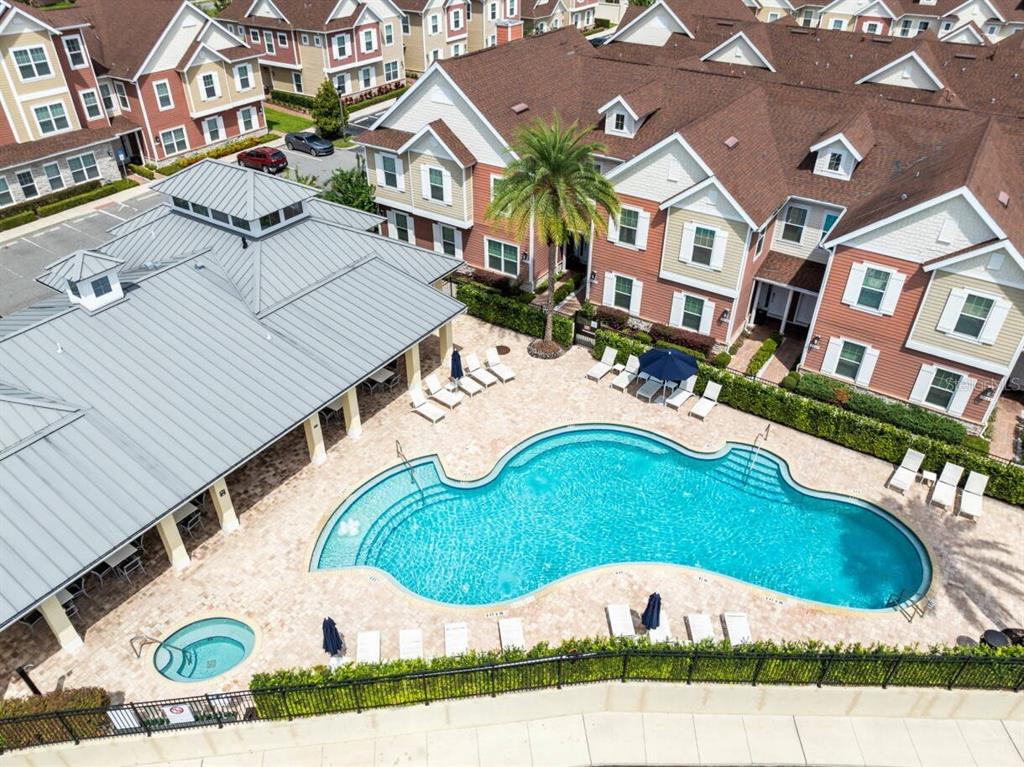 An aerial view shows a community swimming pool and hot tub surrounded by apartment buildings — 7514 SUNVILLE AVENUE, KISSIMMEE, FL
