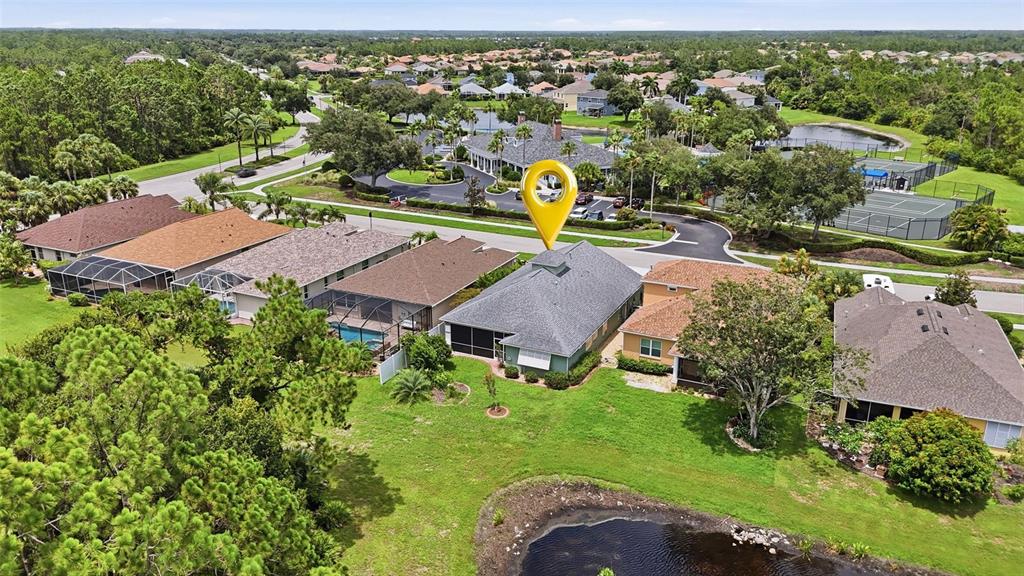 An aerial view shows a residential house with a pool cage near a pond — 1509 SCARLETT AVENUE, NORTH PORT, FL