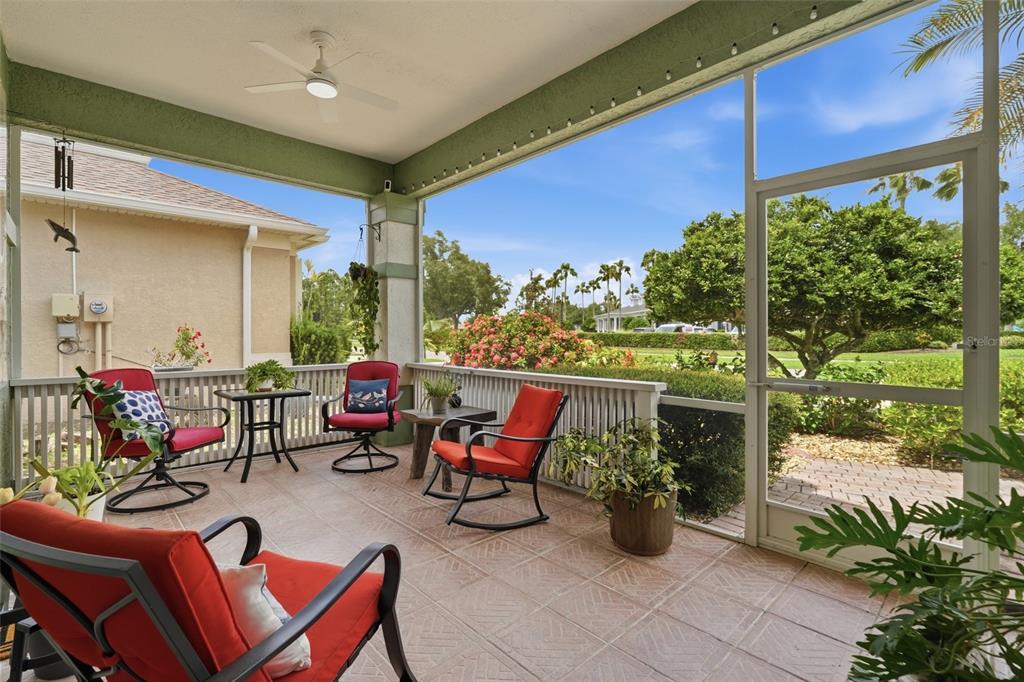 A screened-in porch with tiled flooring, patio furniture, and a ceiling fan overlooks a yard — 1509 SCARLETT AVENUE, NORTH PORT, FL