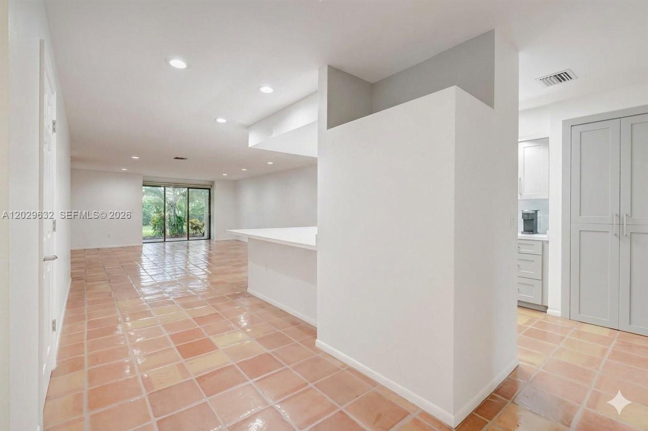 An open-concept living area features light-colored tile flooring and a white kitchen peninsula — 5375 10th Fairway Dr # 2, Delray Beach FL 33484, DELRAY BEACH, FL