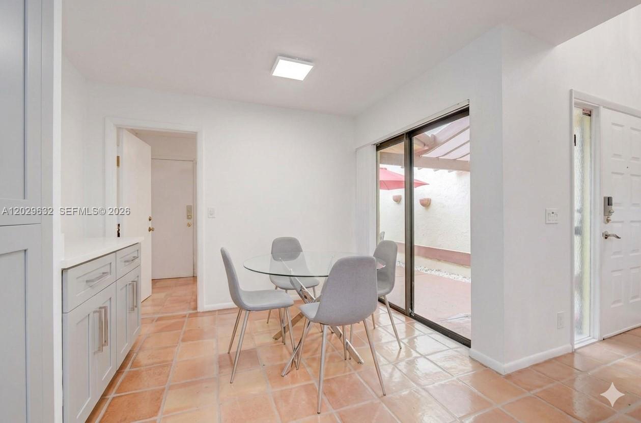 A dining area features a glass table, four gray chairs, and tile flooring — 5375 10th Fairway Dr # 2, Delray Beach FL 33484, DELRAY BEACH, FL