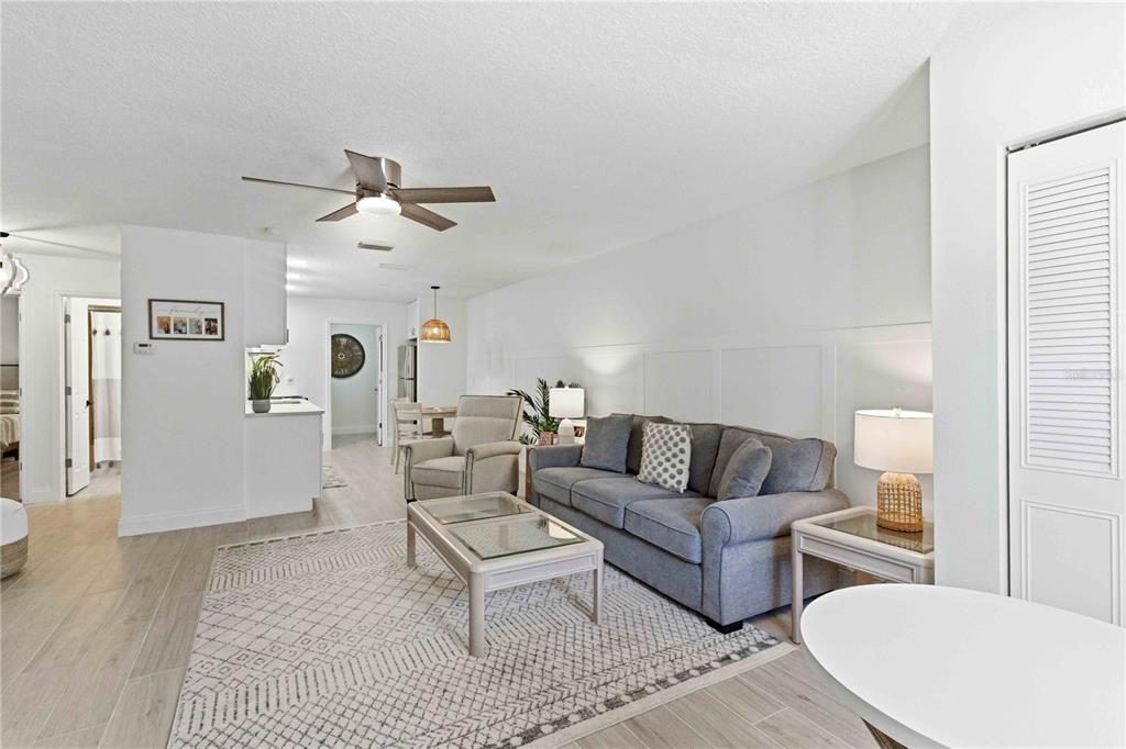 A living room features a gray sofa, a glass-topped coffee table, and light wood flooring — 4237 66TH STREET CIRCLE W UNIT S-4237, BRADENTON, FL