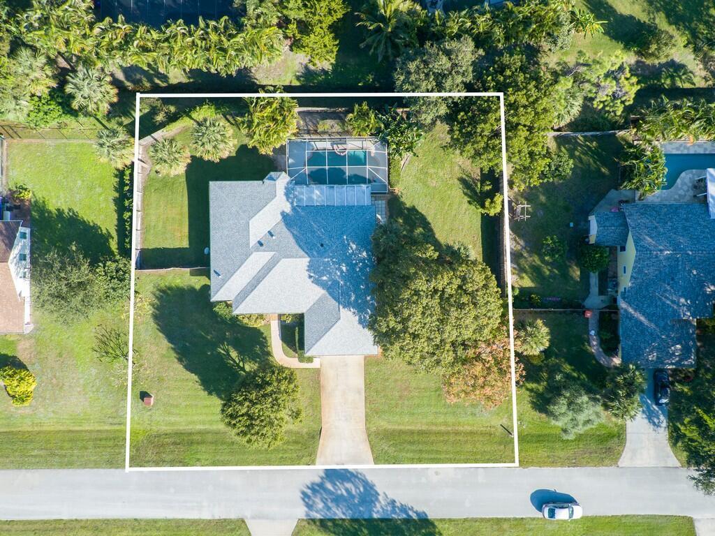 An aerial view shows a single-family home with a screened pool and a large yard — 6130 60th Court, Vero Beach FL 32967, VERO BEACH, FL