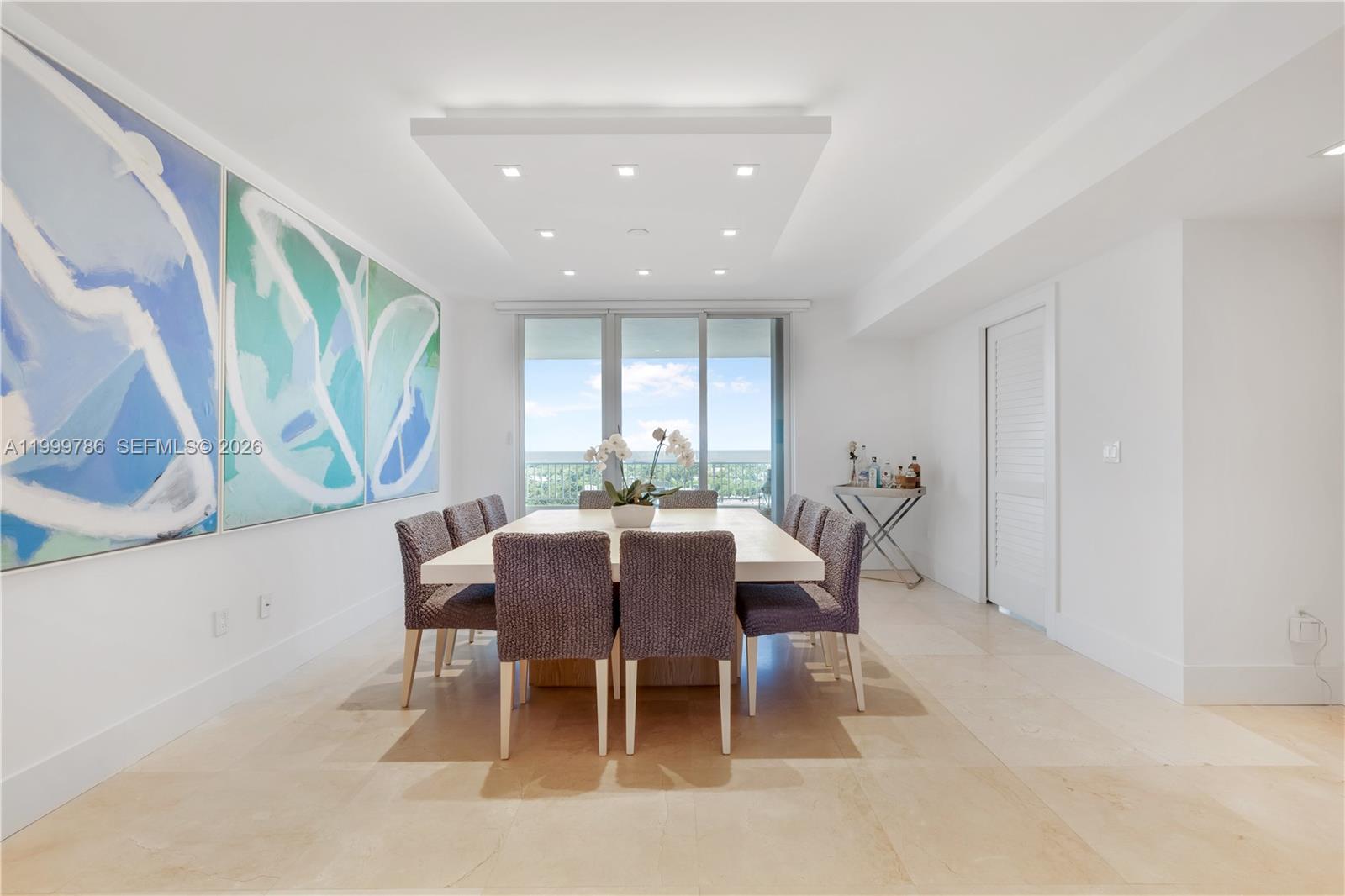A dining room features a large square table, gray chairs, and abstract wall art — 789 Crandon Blvd # 1003, Key Biscayne FL 33149, KEY BISCAYNE, FL