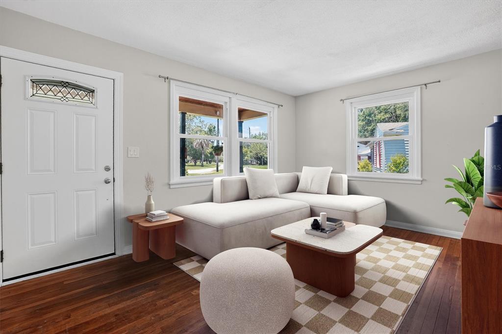 A living room features a white sectional sofa, a checkered rug, and dark wood floors — 5503 LAKEWOOD CIRCLE E, JACKSONVILLE, FL