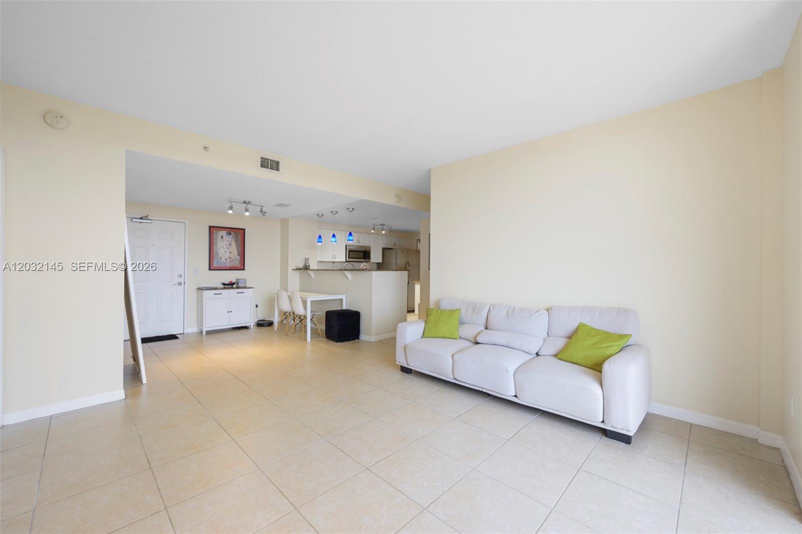 A living room features light tile floors, a white sofa with green pillows, and a kitchen — 215 SW 42nd Ave # 708, Miami FL 33134, MIAMI, FL