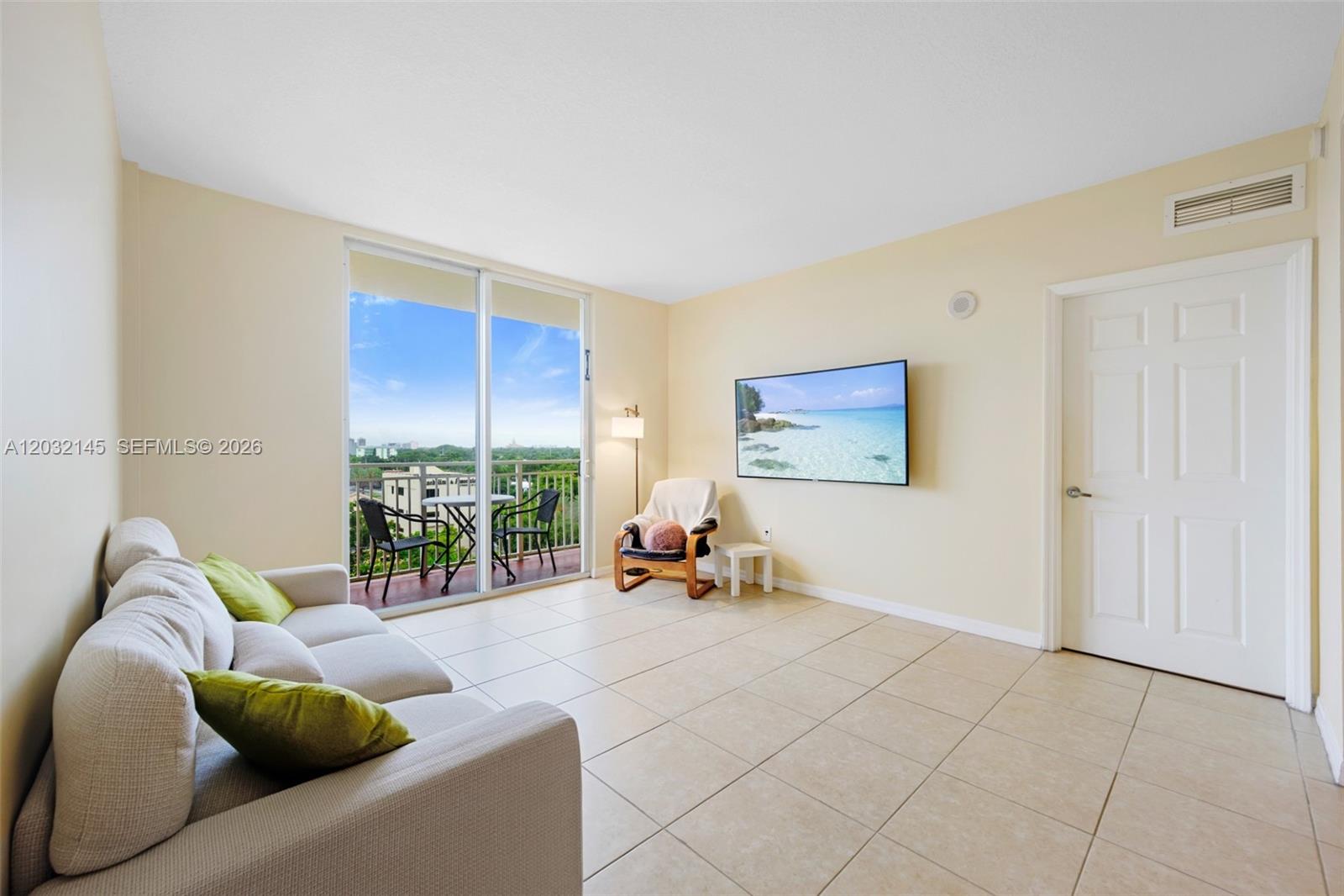 A living room features light tile floors, a wall-mounted television, and a balcony with seating — 215 SW 42nd Ave # 708, Miami FL 33134, MIAMI, FL